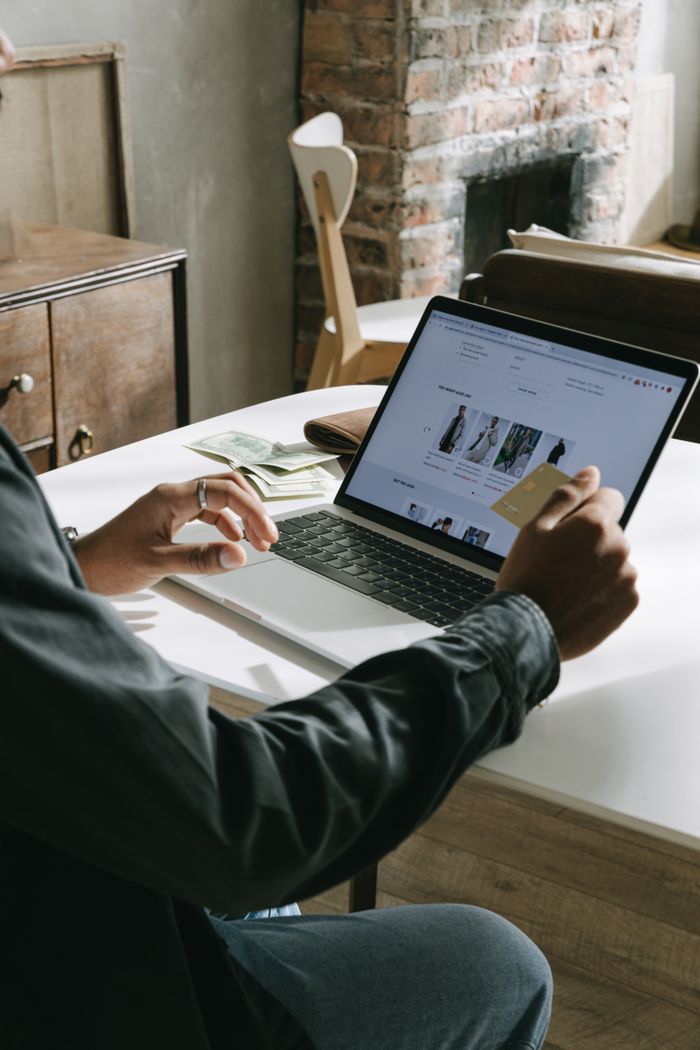 Mastering the First Impression: Your intriguing post title goes here An adult uses a credit card for online shopping on a laptop indoors.